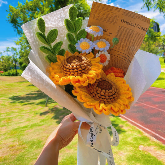 Mazzo di fiori in crochet fatti a mano con girasoli e margherite, avvolto in carta Kraft e con fogli di giornale marrone per la laurea, le vacanze estive o come segno di riconoscenza