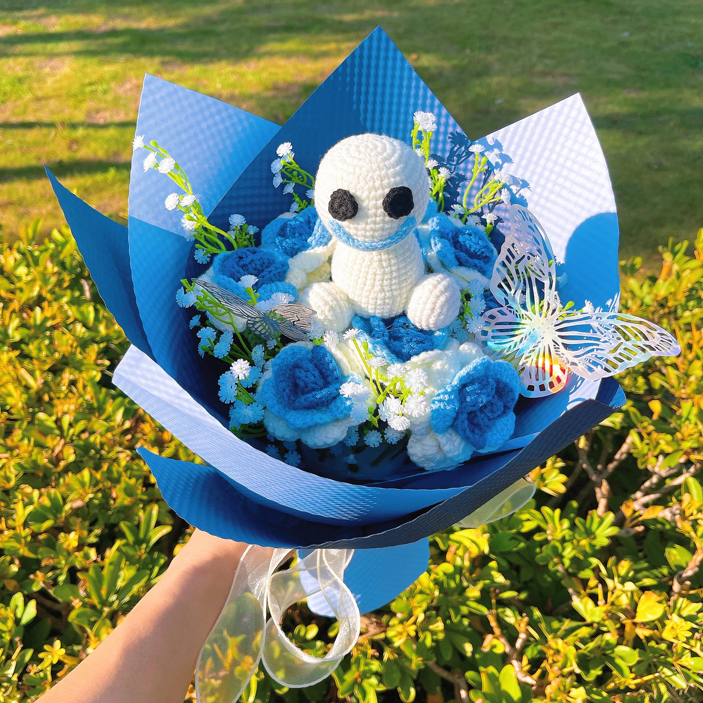 冰霜白藍漸層玫瑰花束,搭配純白滿天星與繽紛彩蝶裝飾,以淺藍與深藍紙材精美包裝,宛如公主慶典的夢幻之選