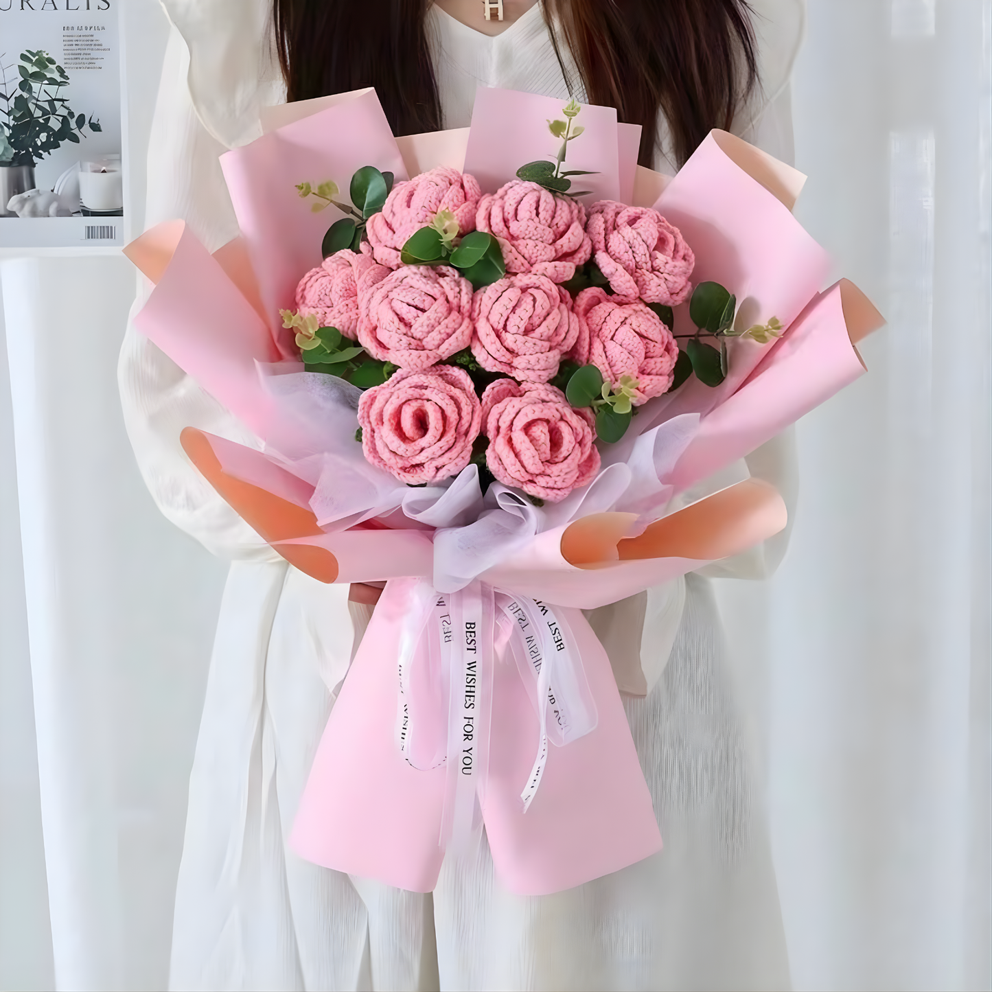 Bouquet of pink flowers wrapped in pink paper with a white ribbon.