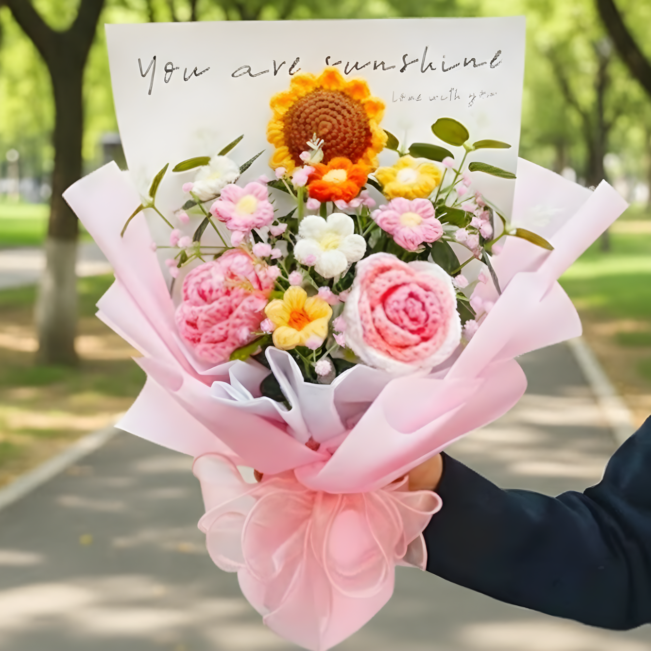 Bouquet of flowers with a card reading 'You are sunshine' held outdoors.