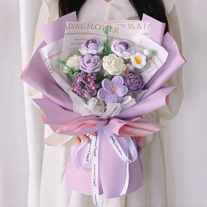 Bouquet of purple and white flowers wrapped in pink paper held by a person.