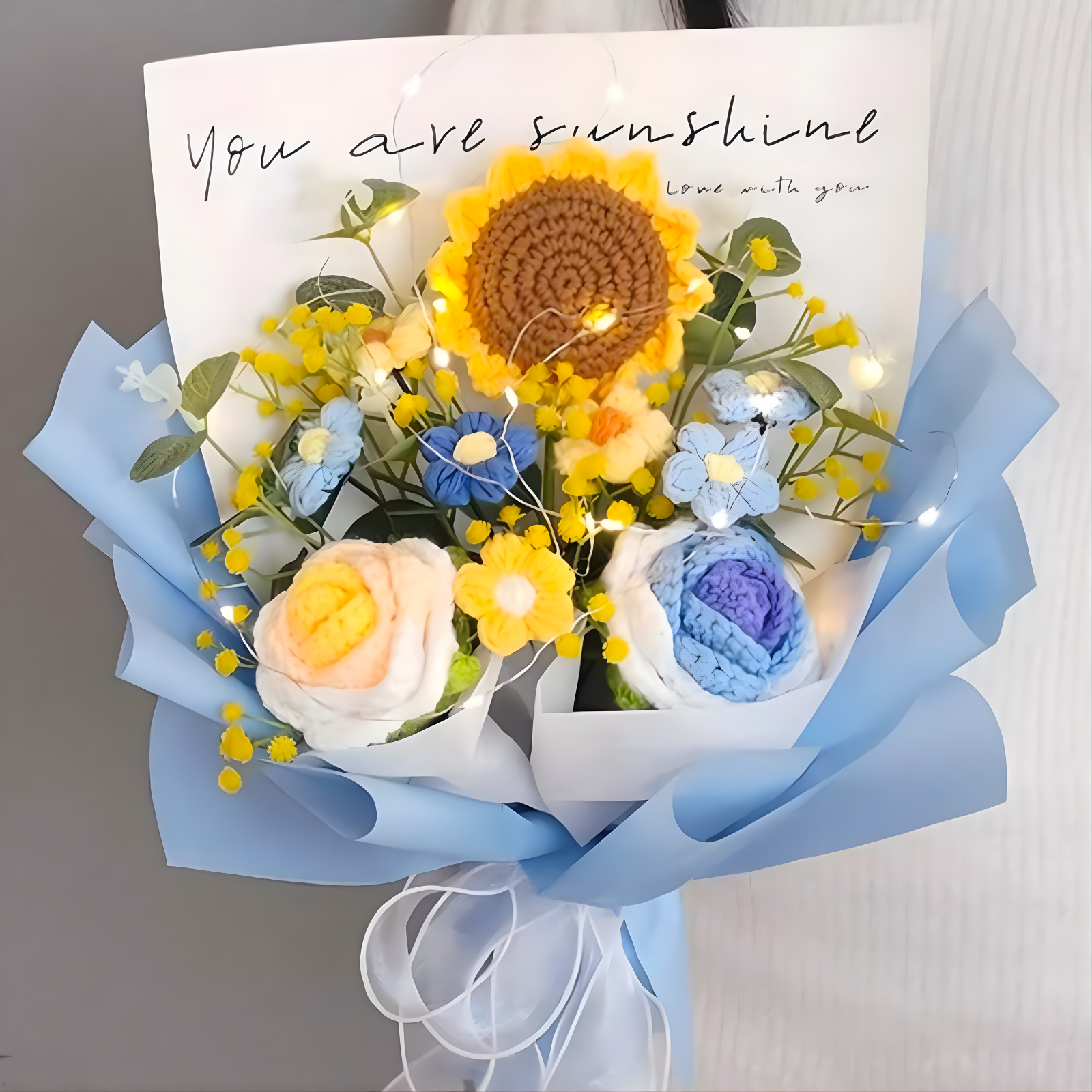 Bouquet of flowers with a card reading 'You are sunshine' on a neutral background