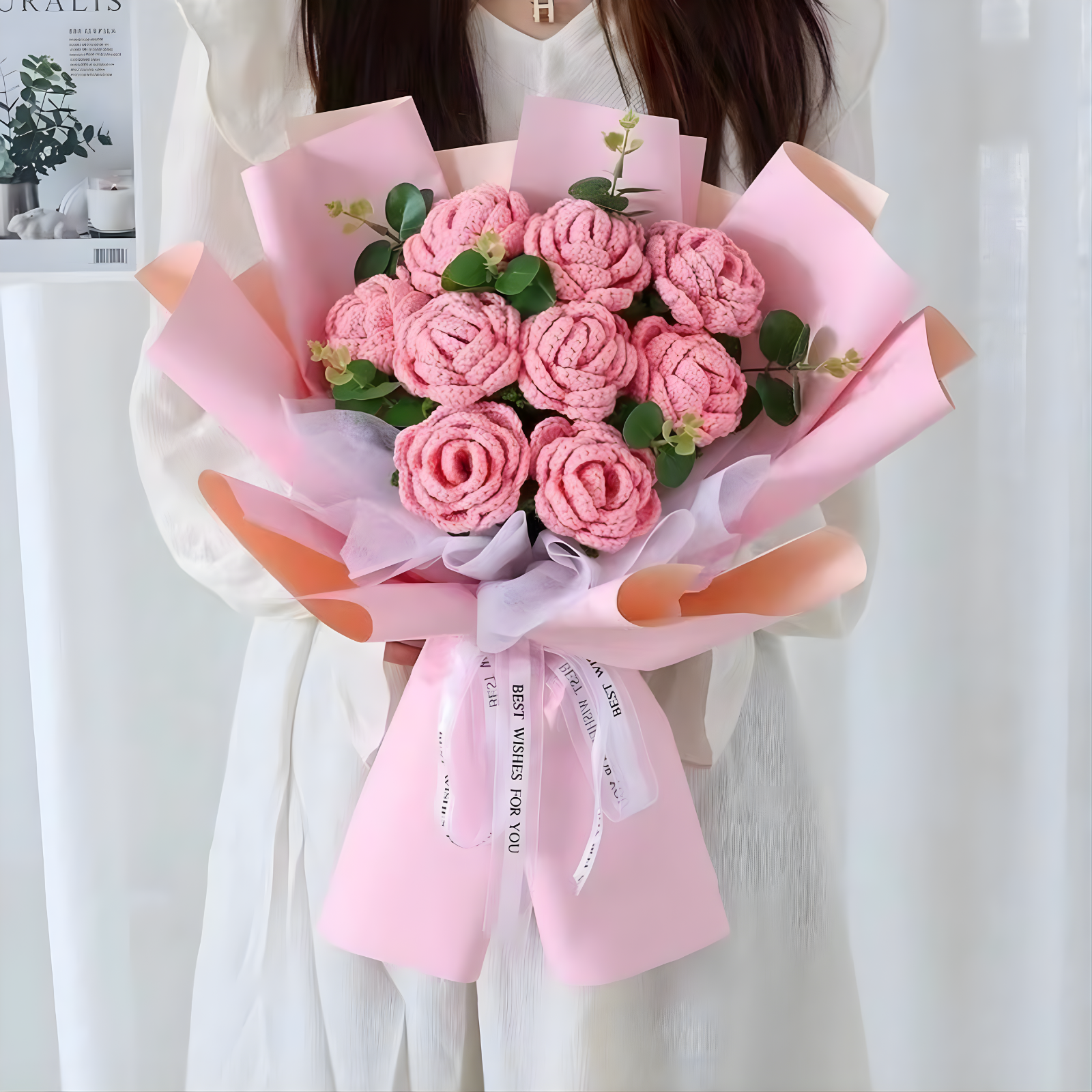 Bouquet of pink flowers wrapped in pink paper with a white ribbon.