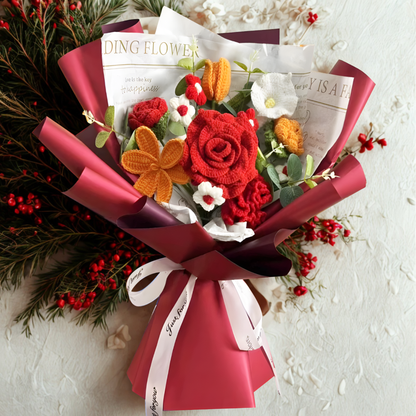 Bouquet of flowers with red and orange colors, wrapped in pink paper with a white ribbon on a light background.